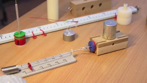 Close-up of a student's hands moving a physics model across a table. Stock Footage 207934193