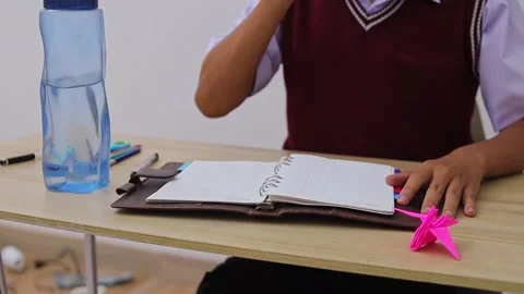 Close-up of student’s hands pouring drink into cup while studying Stock Footage 335018143