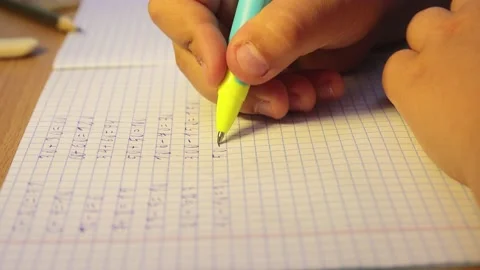Close-up of a student's hands write mathematical examples in a notebook. Stock Footage 207933513
