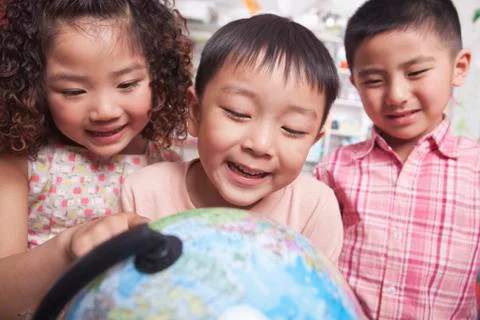 Close Up of Students Looking at a Globe Stock Photos