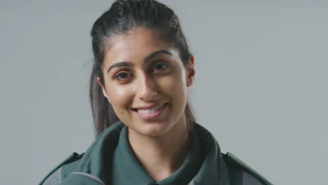 Close Up Studio Portrait Of Smiling Young Female Paramedic Against Plain Video stock 152438066