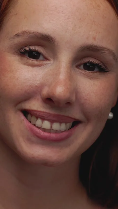 Close-up studio portrait of young redhead woman with freckles smiling at camera Stock Footage 316850045