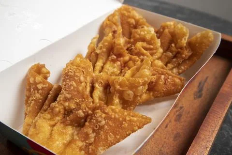 A close-up studio shot of a batch of crispy fried wontons inside an open pa.. Stock-Fotos