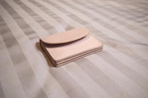 A close-up studio shot of a closed light pink leather cardholder or small w.. Stock-Fotos