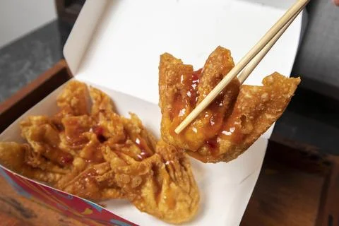 A close-up studio shot of a crispy fried wonton drizzled with sweet chili s.. Fotos Stock