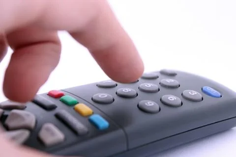 Close up studio shot of hand pressing remote control button isolated on white Stock Photos