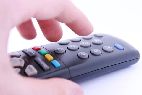 Close up studio shot of hand pressing remote control button isolated on white Stock Photos