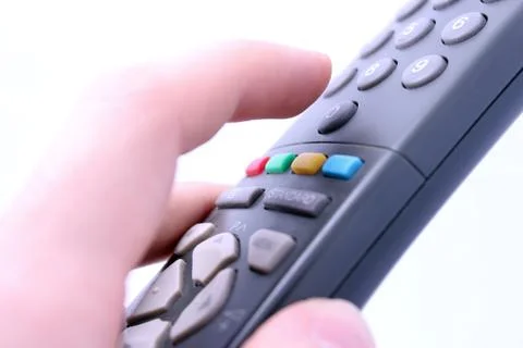 Close up studio shot of hand pressing remote control button isolated on white Stock Photos
