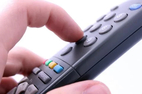 Close up studio shot of hand pressing remote control button isolated on white Stock Photos