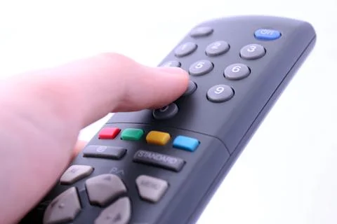 Close up studio shot of hand pressing remote control button isolated on white Stock Photos