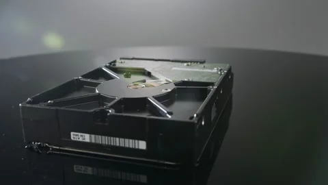 Close up studio shot of a hard drive rotating on reflective surface Video stock 202915017
