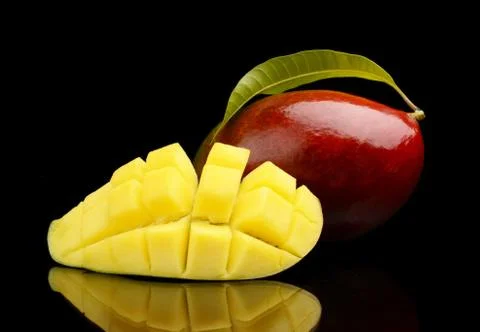 Close-up studio shot mango fruit with slice and leaf isolated on black backgr Stock Photos