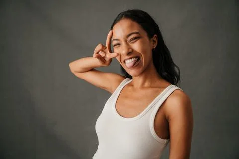 Close up studio shot of multi ethnic woman in casual clothing showing the peace Stock Photos
