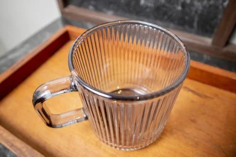 A close-up studio shot of a single upright ribbed glass mug with a square h.. Stock Photos