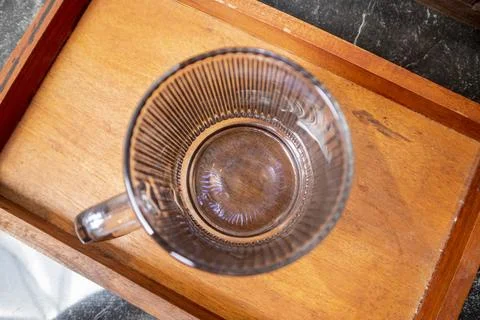 A close-up studio shot of a single upright ribbed glass mug with a square h.. Stock-Fotos