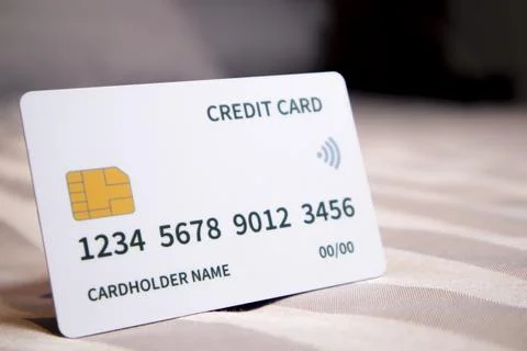 A close-up studio shot of a single white credit card resting upright on a s.. Fotos de archivo