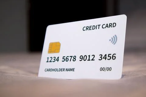 A close-up studio shot of a single white credit card resting upright on a s.. Stock-Fotos