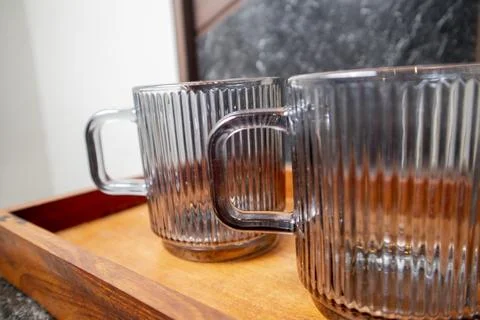 A close-up studio shot of two ribbed glass mugs with square handles on a wo.. Stock Photos