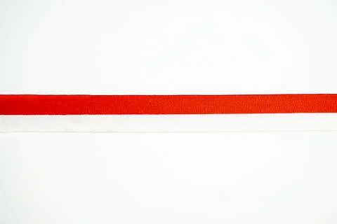 A close-up studio shot of a two-tone ribbon strip featuring vibrant red and.. Stock Photos