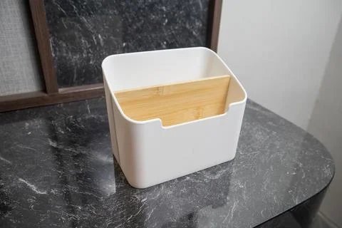 A close-up studio shot of a white plastic desktop organizer with a wooden d.. 스톡 사진