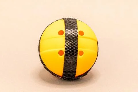 A close-up studio shot of a yellow plastic ball featuring black hook-and-loop Stock Photos