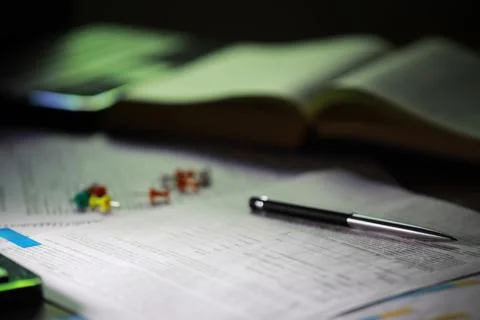 Close-Up of Study Desk with Open Book, Pen, and Colored Pushpins" Stock Photos