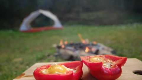 Close up of stuffed red peppers with cheese and eggs near campfire Stock Footage 271626123