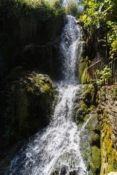 Close-up of a stunning waterfall flowing through lush greenery in Tobera, S.. Stock Photos