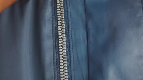 Close up of a sturdy zipper on a blue jacket fabric Stock Footage 312655660