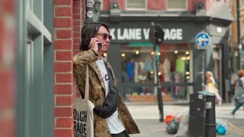 Close up of stylish Asian man talking on the phone in Brick Lane, London, UK Stock Footage 305152841