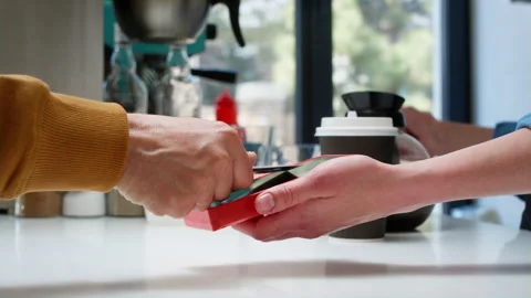 Close-up: a stylish old man makes a purchase in a coffee shop, pays with a bank Stock Footage 244096023