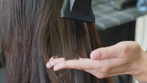 Close up of stylist use hair dryer blow woman's hair after hair dyeing at salon. Stock Footage
