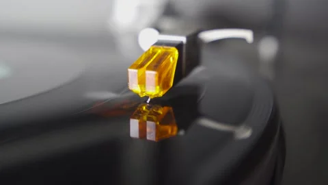Close-up on stylus reflected on shiny black vinyl spinning on turntable Stock Footage 257777319
