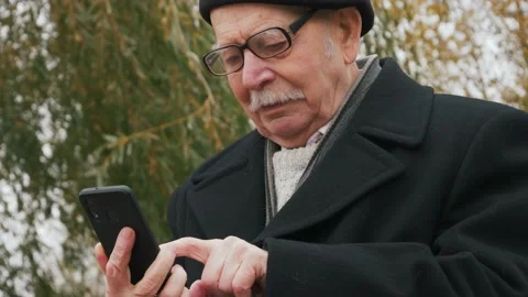 Close-up of a successful senior businessman using a smartphone in the park Stock Footage 143728091
