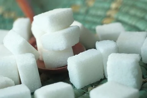 Close up of sugar cube on spoon on table Stock Photos