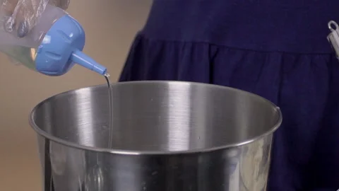 Close up of sugar syrup is being poured to the steel bowl by female confectioner Video stock 86038395