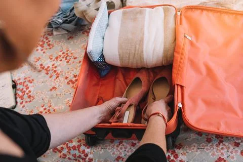 Close-up of a suitcase being packed for a summer holiday. a woman's hands Stock Photos