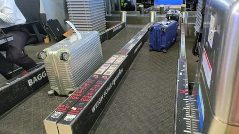 Close-up of a suitcase being placed on the conveyor belt at an airport. Stock Footage 300364466