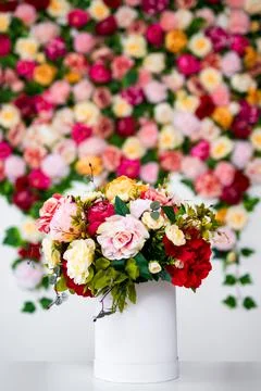 Close up of summer bouquet of flowers in box or vase over colorful background Stock Photos