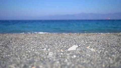 Close-up of summer pebble beach, blue sea waves washing shore. Place for relax Stock Footage 133129695