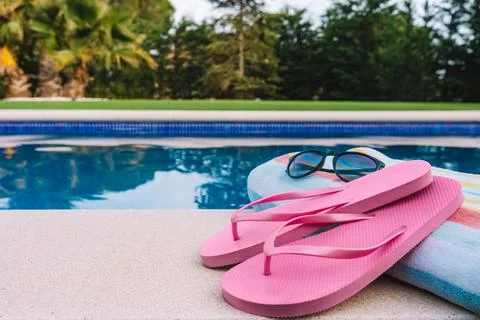 Close up of summery swimming objects in front of a swimming pool. beach towel Stock Photos