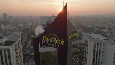 Close-up of the sun peeking out from behind the hard rock hotel symbol Vidéo 228422120