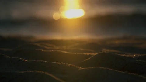 Close up of sundown reflecting of sea waves and beach sand Stock Footage 125213173