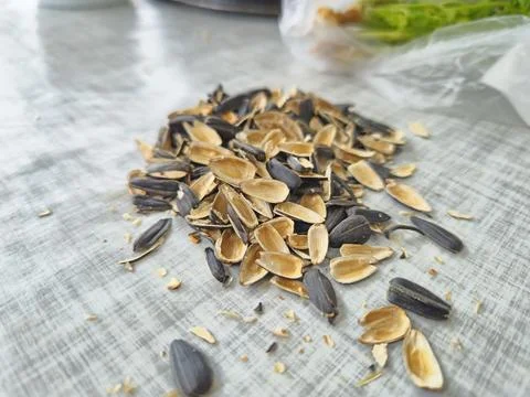 Close-Up of Sunflower Seed Shells Spread Across a White Surface Foto stock
