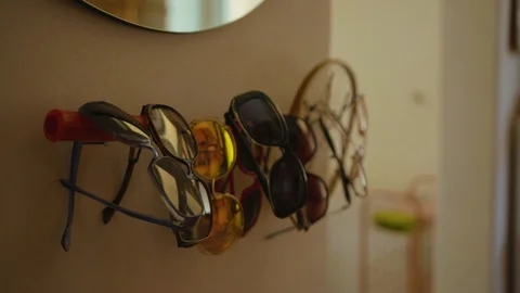 Close up of sunglasses hanging on wall in retro vintage apartment decor design Stock Footage 118869499