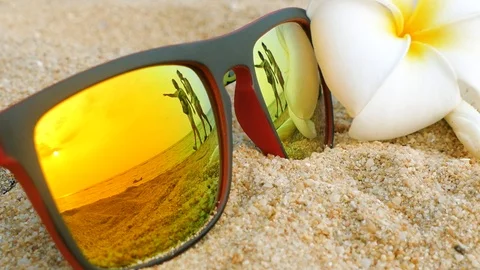 Close Up Sunglasses lying on the beach and reflecting the  happy couple Stock Footage 102594795