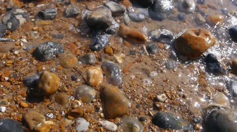Close-Up Sunlight and Waves Hit Stony Beach Stock Footage 25891430