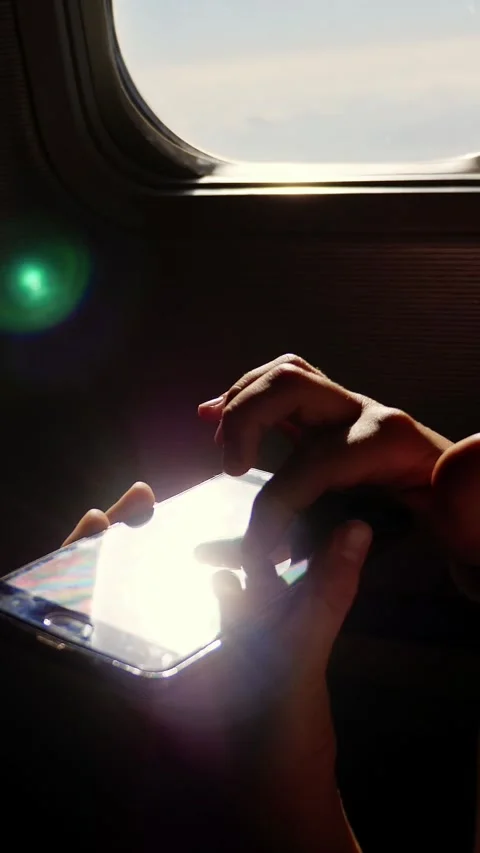 Close-up. the sun's rays are reflected in the phone. dark silhouette of kid Video stock 322116029