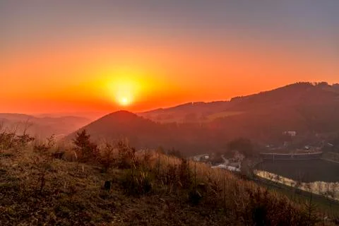Close up sunset timelapse when sun is behind hills and mountains full of tree Stock-Fotos