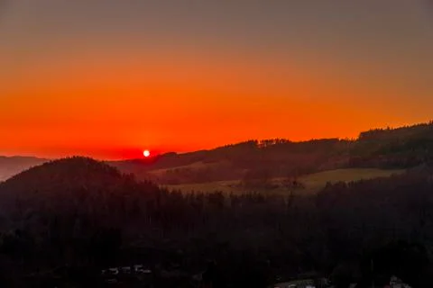Close up sunset timelapse when sun is behind hills and mountains full of tree 스톡 사진